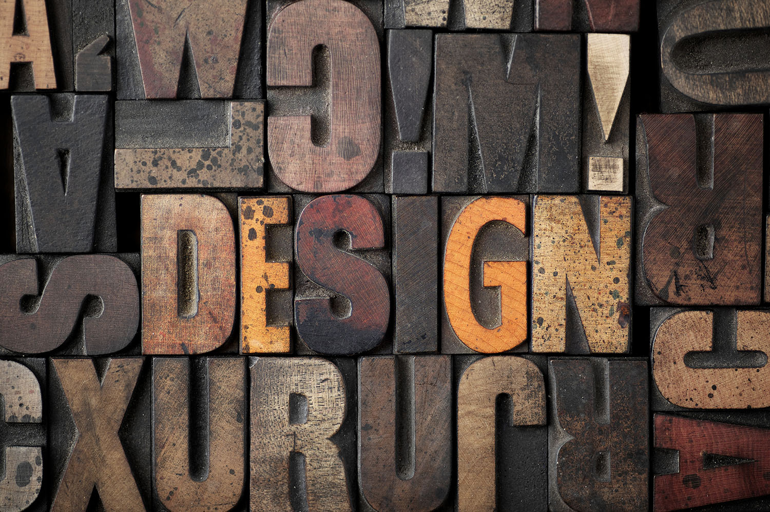 The word 'DESIGN' spelled out in very old letterpress blocks.