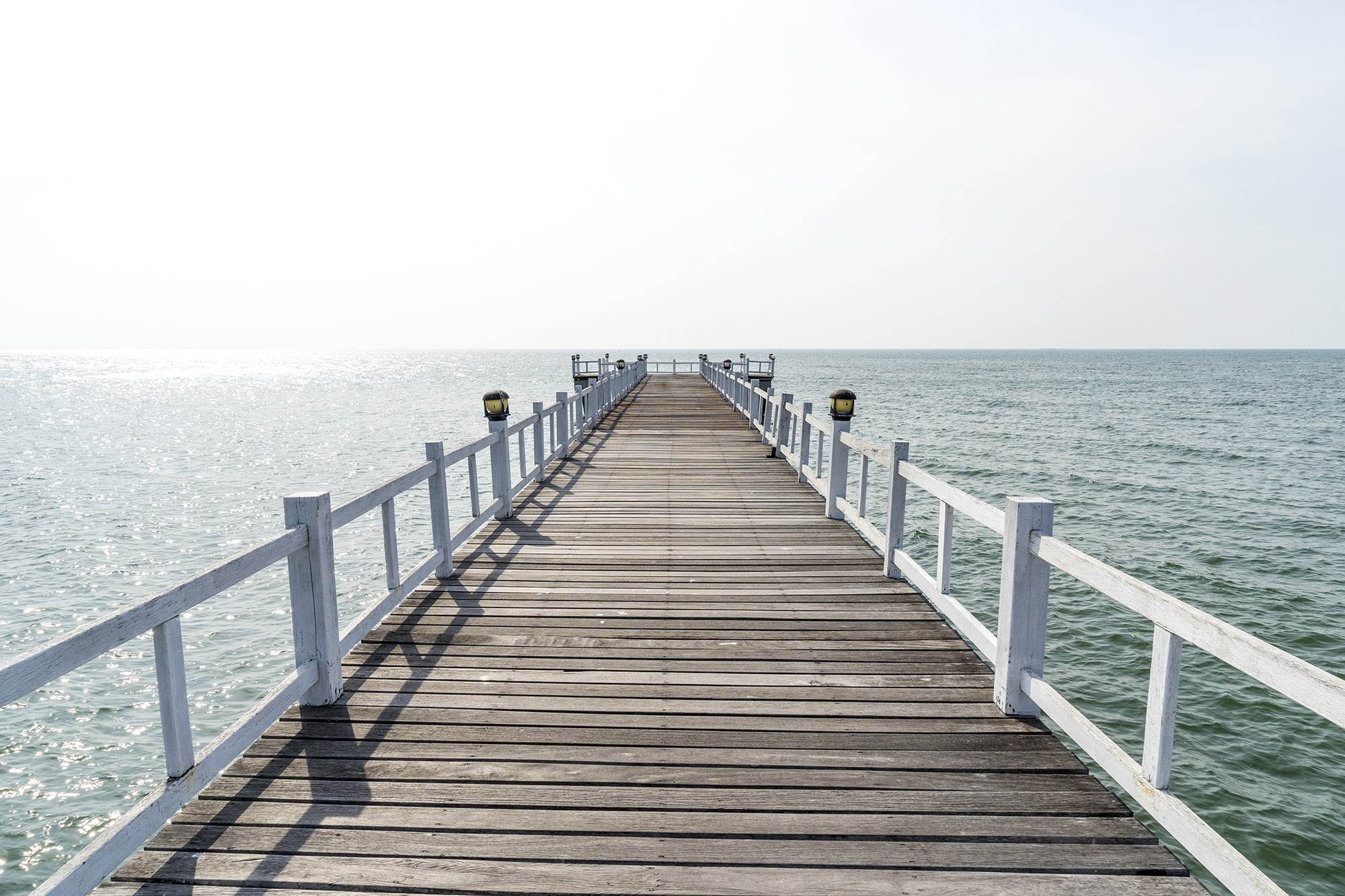 The wooden bridge walkway into the sea.